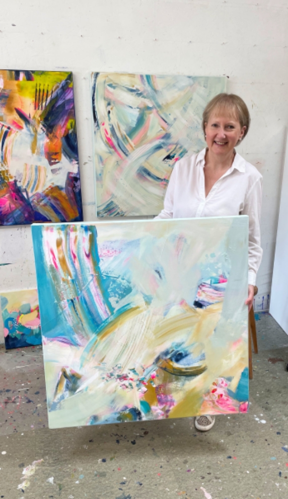 Alison J Gilbert in her studio with abstract painting "Summer Breeze"